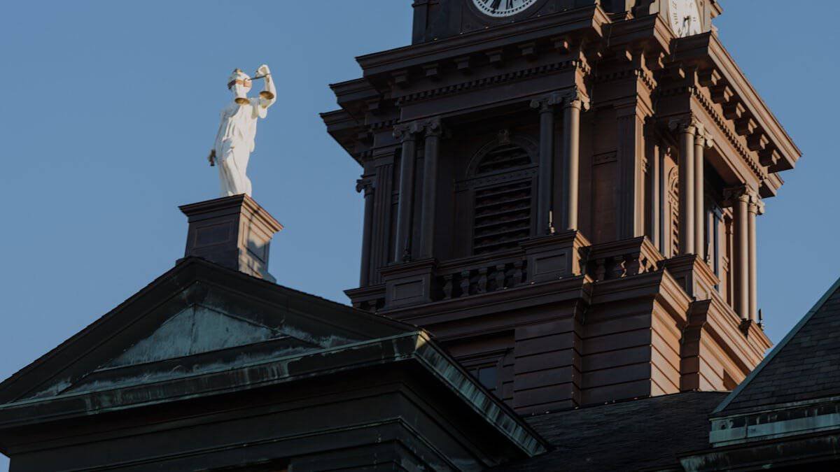 Palacio de justicia con torre y estatua, ilustrando la Defensa Publica en Republica Dominicana